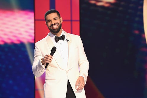 Drake wearing a white blazer and shirt with a black bow tie, and black pants at the 2019 Billboard M...
