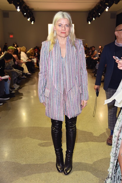 Celebrity stylist Kate Young in a striped oversized blazer and a pair of black over-the-knee boots a...
