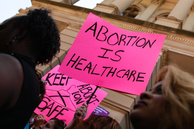A woman holding a sign reading: 'Abortion is healthcare.'
