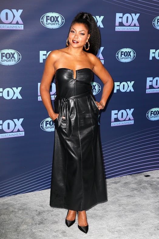Taraji P. Henson posing with a textured high ponytail hairstyle in a black dress