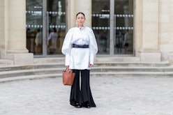 Stylist Rachael Wang standing in front of a building in a white and black outfit featuring everythin...