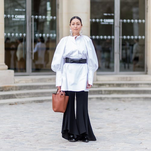 Stylist Rachael Wang standing in front of a building in a white and black outfit featuring everythin...
