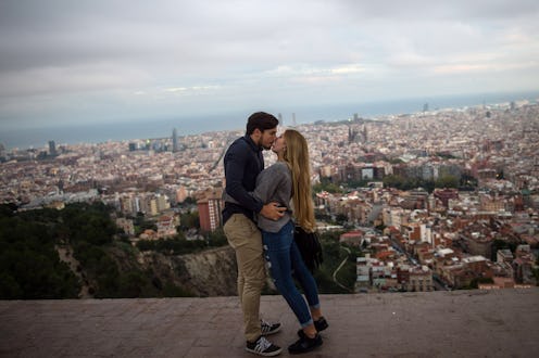 A couple sharing a romantic kiss overlooking a city skyline during spring break