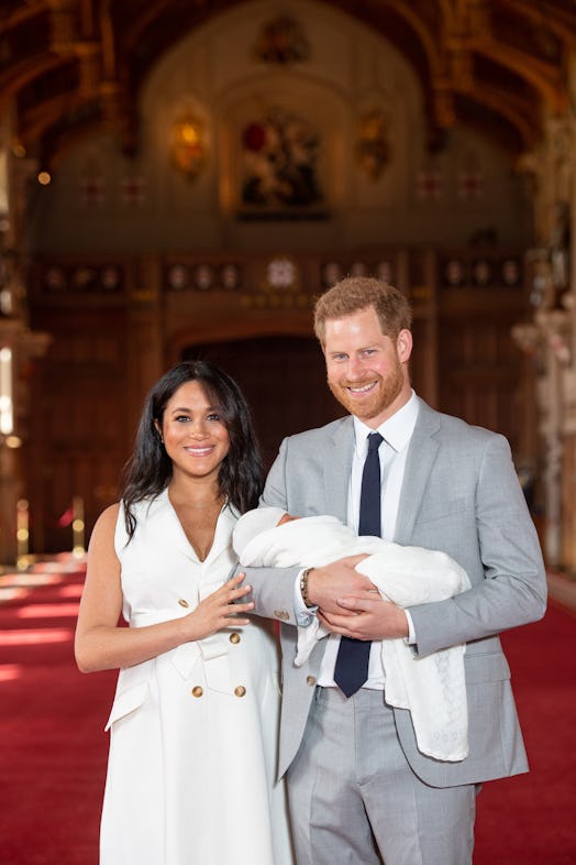 Harry and Meghan posing for a photo with baby Sussex