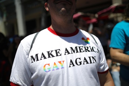 A man wearing a shirt that says make america gay again at a pride event