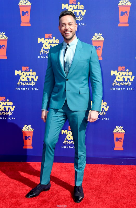 Zachary Levi at the movie qtv awards wearing a team suit and smiling at the camera