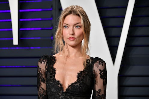Martha Hunt in a black lace dress and an up do with two strands of hair along her face