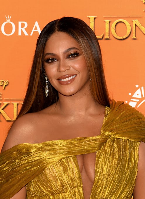 Beyoncé posing in a golden colored dress