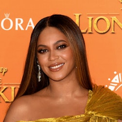 Beyoncé posing in a golden colored dress
