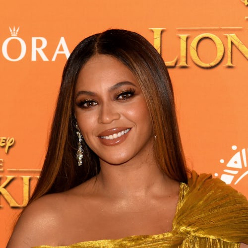 Beyoncé posing in a golden colored dress