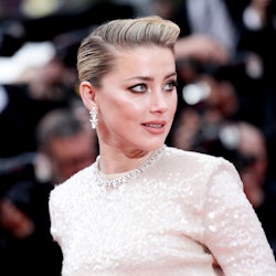 Amber Heard in a glittery white dress, combed over hair at a red carpet event
