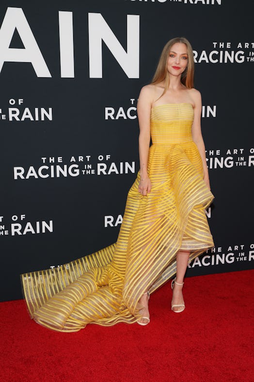 Amanda Seyfried wearing a yellow gown at 'The Art Of Racing In The Rain' premiere