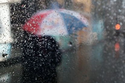 NEW YORK, NEW YORK - JANUARY 24: Pedestrians walk through a heavy late morning rain on January 24, 2...