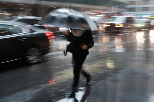 NEW YORK, NEW YORK - JANUARY 24: Pedestrians walk through a heavy late morning rain on January 24, 2...