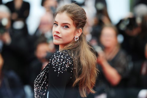 Barbara Palvin posing in a black shirt with her brunette ponytail as the photo highlight