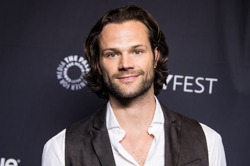 Jared Padalecki on the red carpet wearing an unbuttoned white dress shirt and a black vest