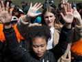 Two girls holding their hands up on protests with "don't shoot" texts on their palms
