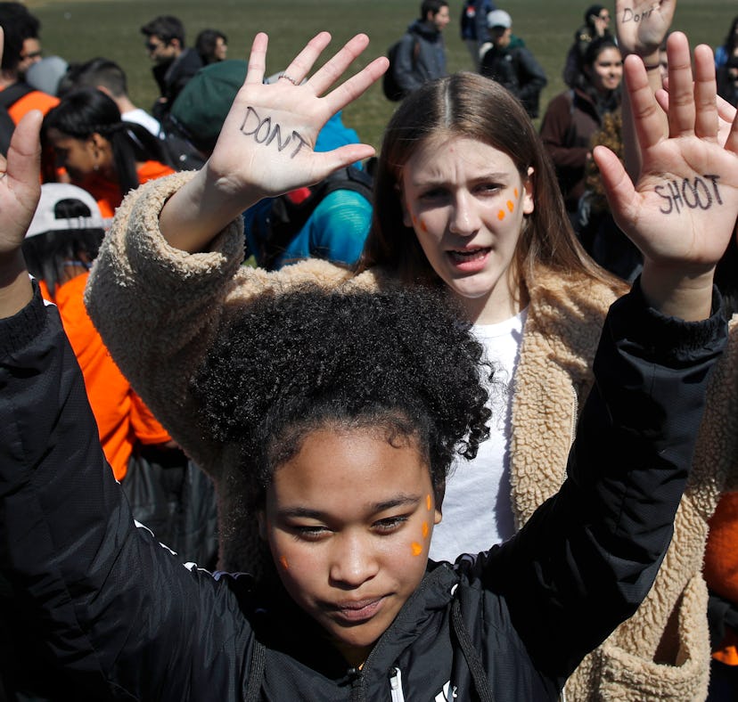 Two girls holding their hands up on protests with "don't shoot" texts on their palms