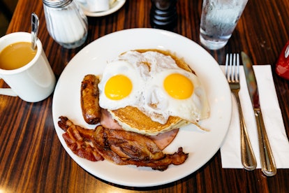 A breakfast at a local diner features eggs, bacon, pancakes, and coffee.