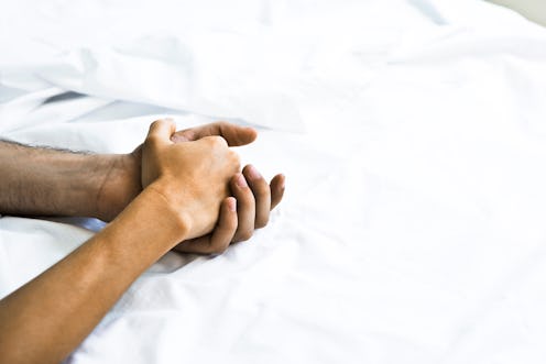 A couple holds hands in bed after sex. Orgasms are different for everyone, but here's what science s...