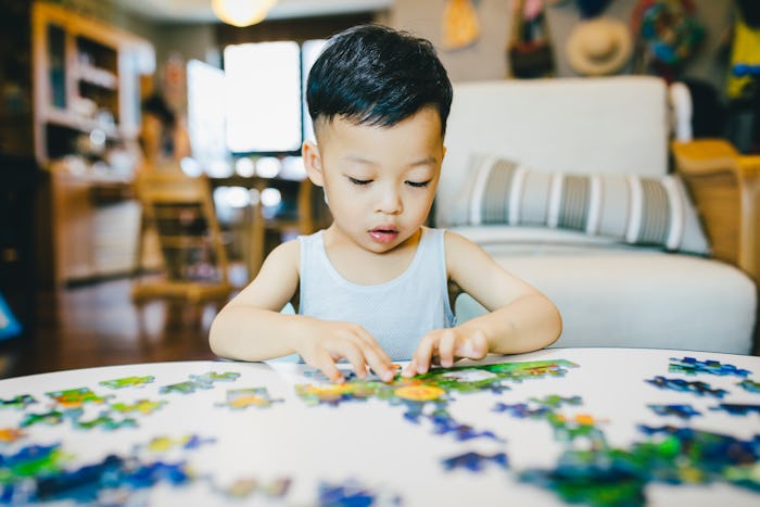 a little boy putting a puzzle together