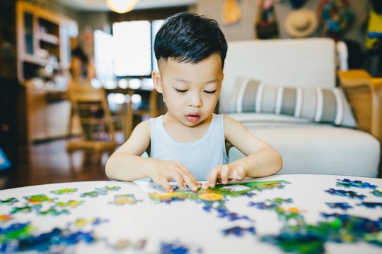 a little boy putting a puzzle together