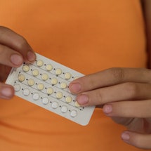 A woman holds a birth control pill pack in her hands. Men still believe lots of myths about birth co...