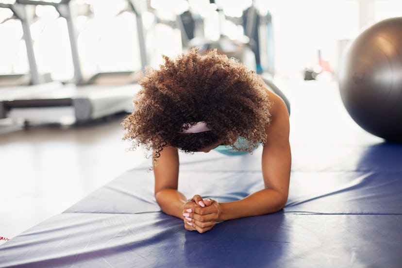 A woman holds a plank. Starting to exercise in the morning is a helpful habit for lifelong fitness.