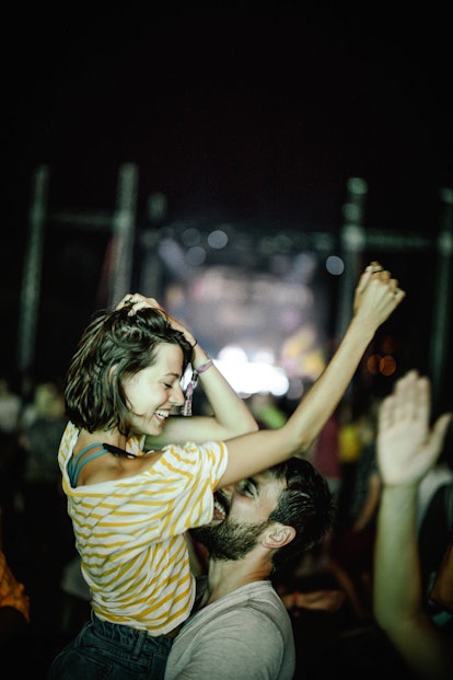 A woman dances with her SO at a lively concert while on a trip. 
