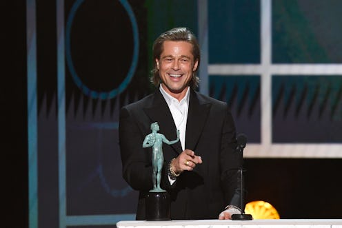 Brad Pitt smiling next to his SAG Awards trophy