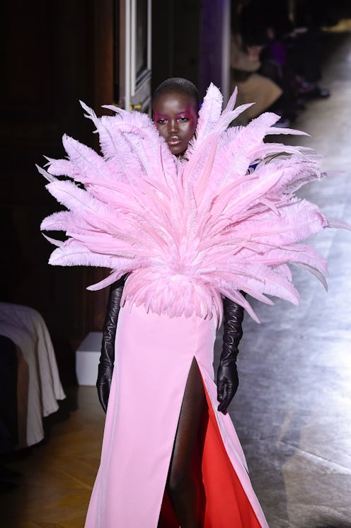 A female model posing in a couture leather pink gown