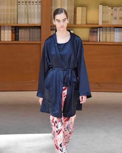A young woman walking in a silk blue couture Chanel bathrob
