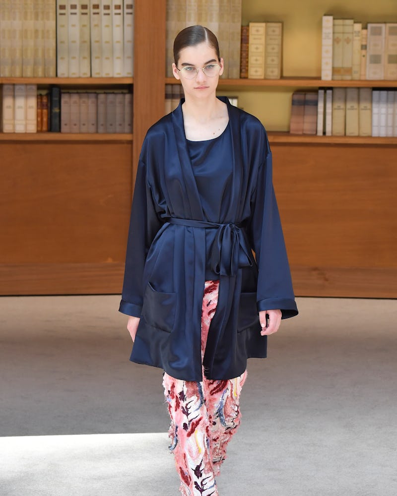 A young woman walking in a silk blue couture Chanel bathrob