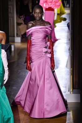 A woman walking in a silk couture pink gown