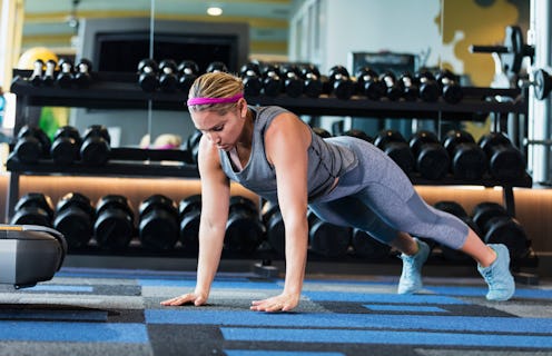 A woman does a pushup, a component of many body positive HIIT workout videos.