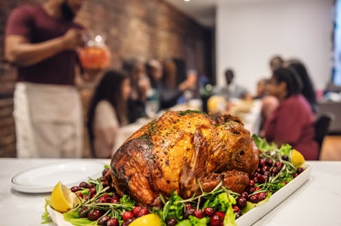 Turkey served on a plate with vegetables with blurred people in the background