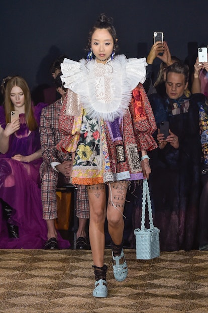 A model in a patchwork dress with a white lace collar as a Spring 2020 trend from the couture runway...