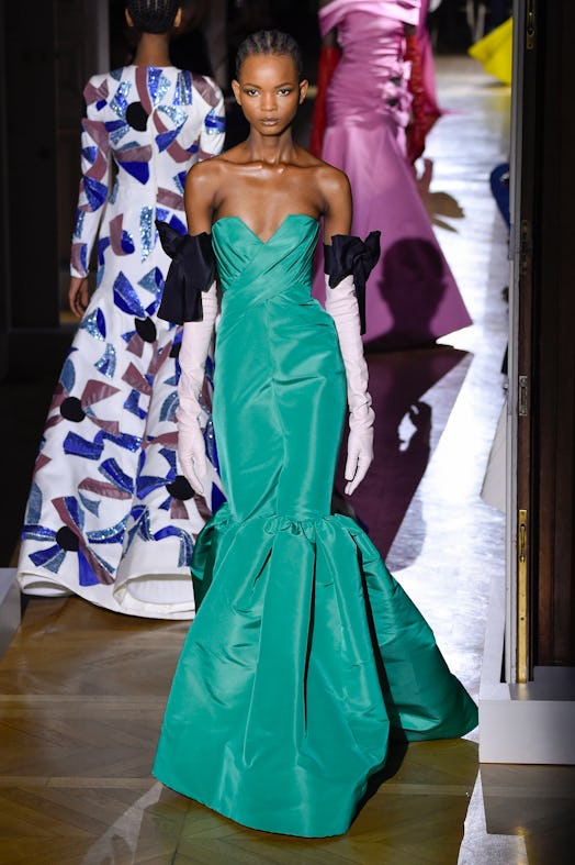 A model in a turquoise gown and black-white gloves as a Spring 2020 trend from the couture runways
