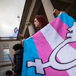 A transgender flag being carried by an activist. Bills denying healthcare to trans youth are based o...