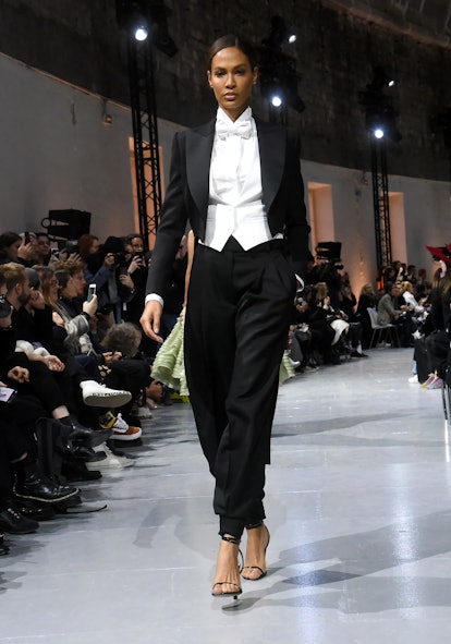 Joan Smalls in a black suit with a white shirt and vest as a Spring 2020 trend from the couture runw...