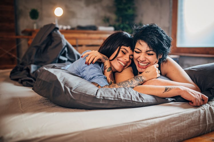 Two women smiling and lying stomach down in their favorite cuddle position