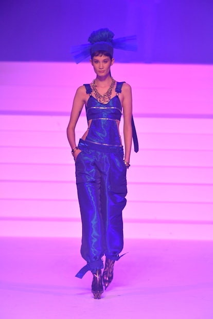 A model in deep blue overalls, boots and tulle headpiece as a Spring 2020 trend from the couture run...