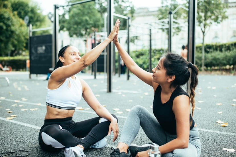 A woman high fives her personal trainer. Personal training has some similarities to finding a therap...