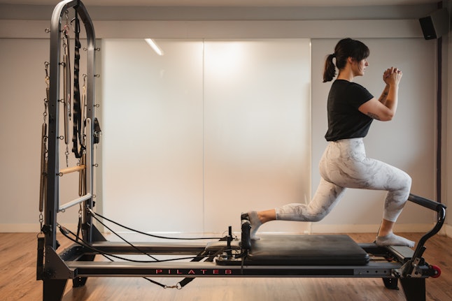 A person exercises on a Pilates reformer. Pilates can help reduce symptoms of depression and anxiety.