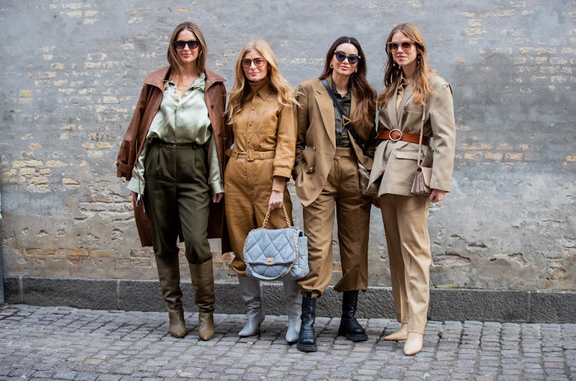 Four women in suits and shirt in camel, brown and beige posing at the street during the Copenhagen F...