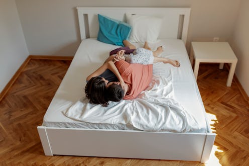 A couple lies in bed together. Ways to help a guy last longer in bed depend on your relationship.