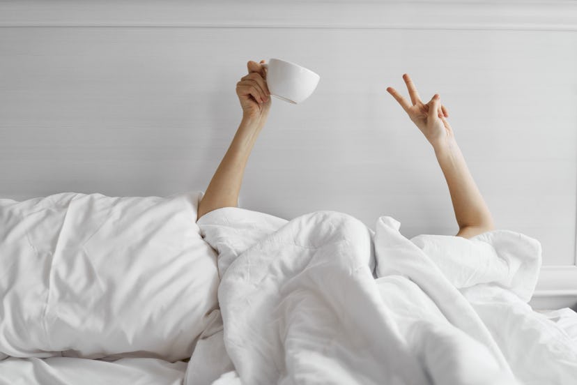 A woman in bed with tea. Alcohol disrupts sleep, so sobriety can improve sleep quality - and that ca...