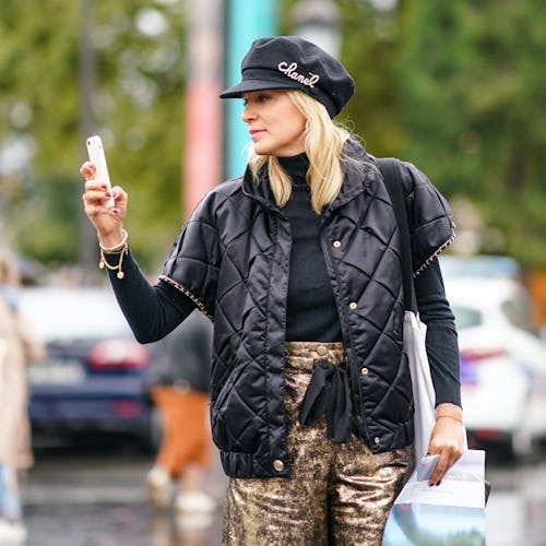 A blonde woman taking a social media break turning of her phone while walking the street