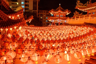 A colorful temple is surrounded by bright, red lanterns for the Lunar New Year. 