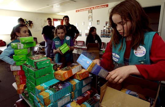 girl scouts sorting boxes of cookies